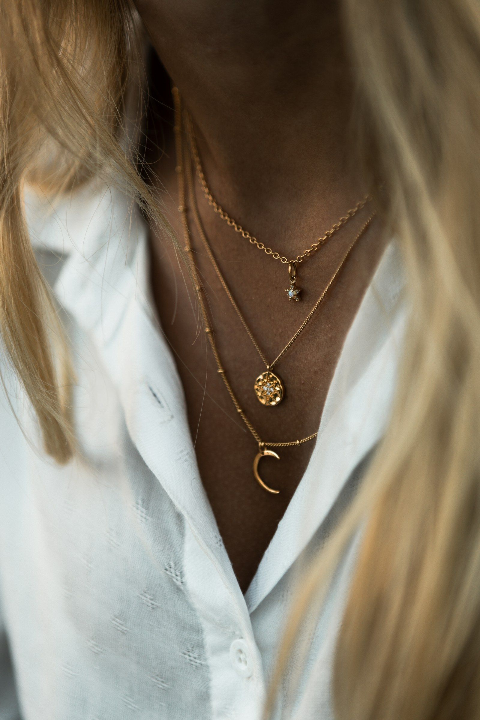 Woman wearing layered gold necklaces